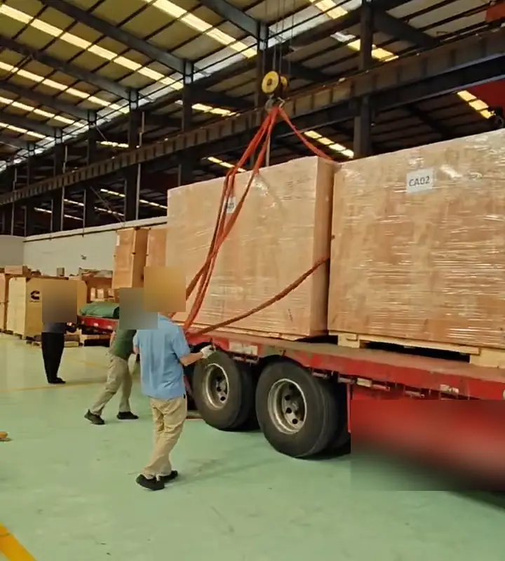 Crated engines being loaded onto a truck by overhead crane